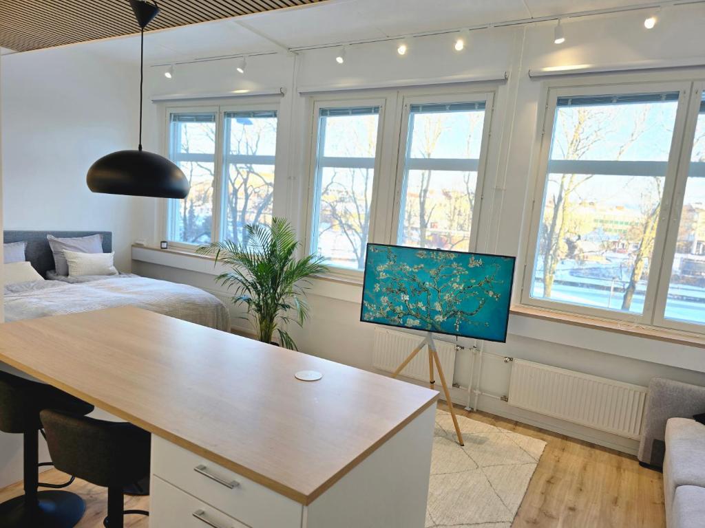 Cette chambre comprend un bureau, un lit et des fenêtres. dans l'établissement Upea asunto Salon sydämessä, Ilmainen pysäköinti, lähellä kaikkea, à Salo