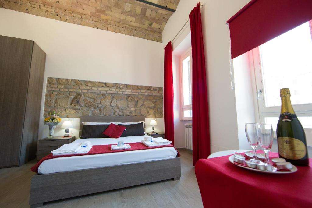 ローマにあるThe Great Beautyのベッドルーム1室(赤いカーテン付きのベッド1台、ワイン1本付)