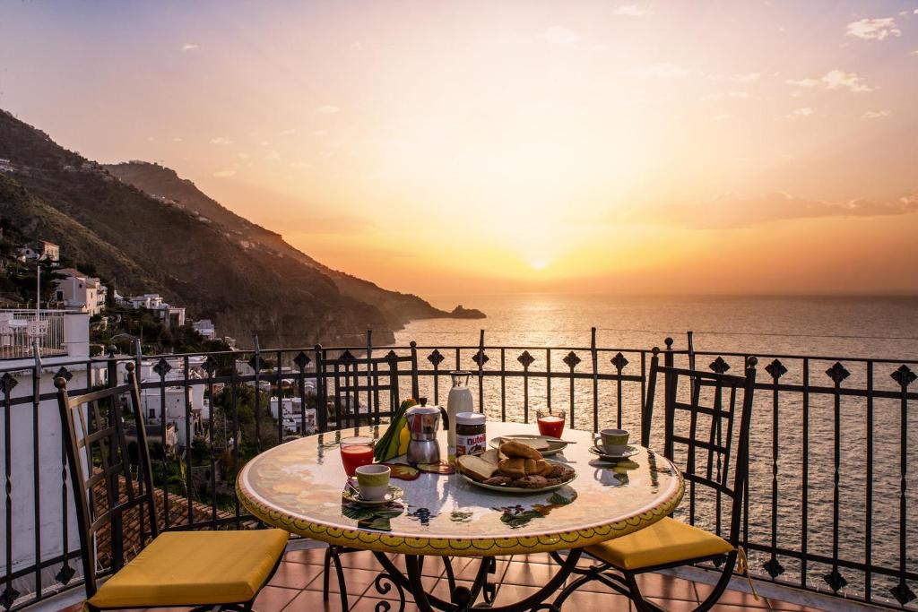uma mesa numa varanda com vista para o oceano em Flatiron app 1 by Sosòre Holiday Homes - Amalfi Coast em Praiano