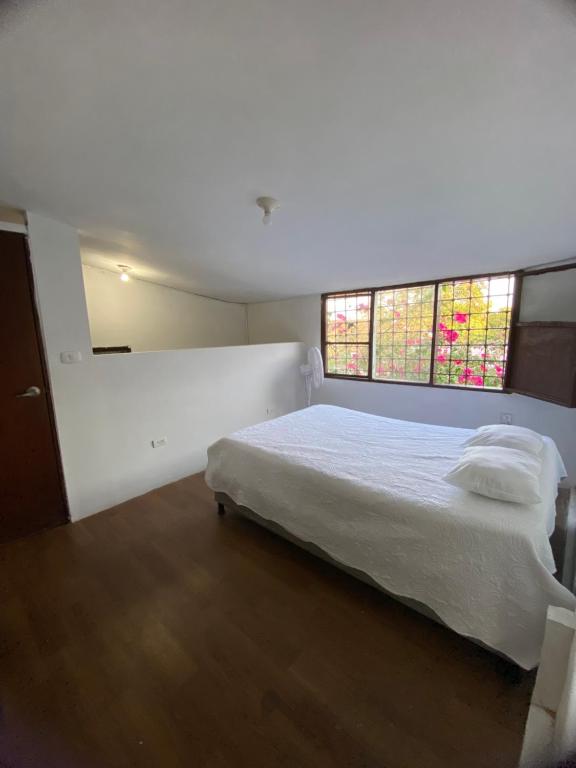 een slaapkamer met een wit bed en een raam bij VEGAN ROOM in Barranquilla