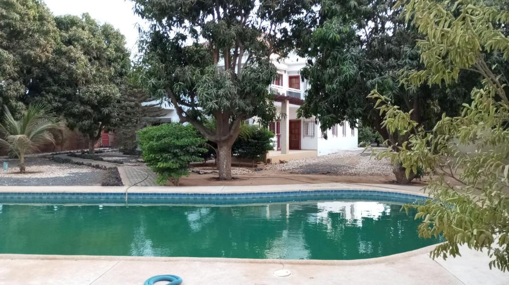a swimming pool in front of a house with trees at Al jannah Bis in Somone