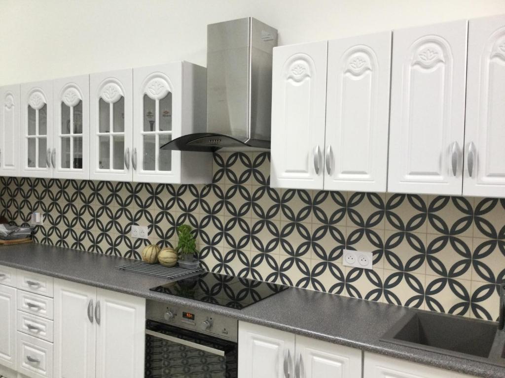 a kitchen with white cabinets and black and white tiles at Gers, Midi-Pyrénées : Séjour de charme à la Résidence d'Auzan in Castelnau-dʼAuzan