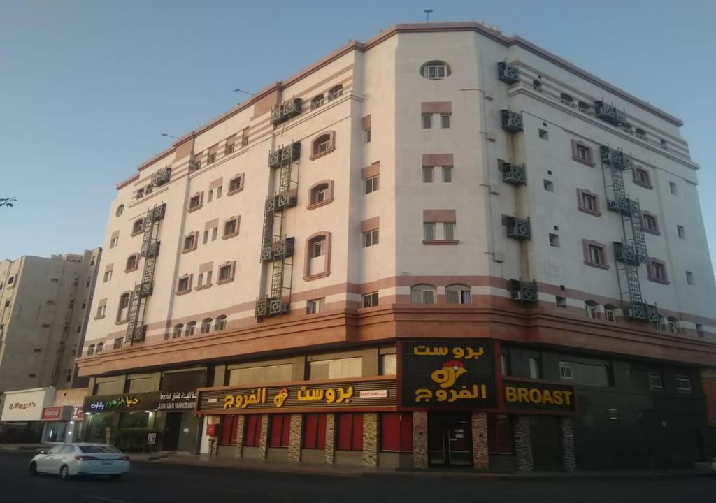 a large white building on the corner of a street at Al Baida Suites Al Salam Branch in Al Madinah