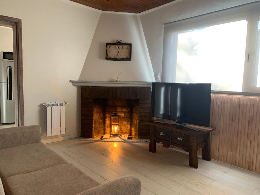 a living room with a tv and a fireplace at CyclosApart in Esquel