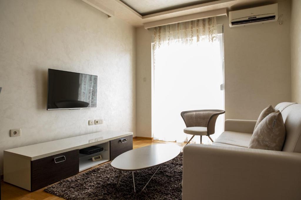 een woonkamer met een bank en een tv bij Vista Suite in Budva