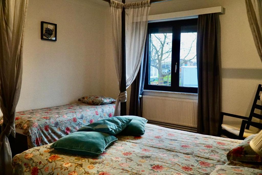 a bedroom with two beds and a window at Vakantiewoning Buitenrijk in Tongeren