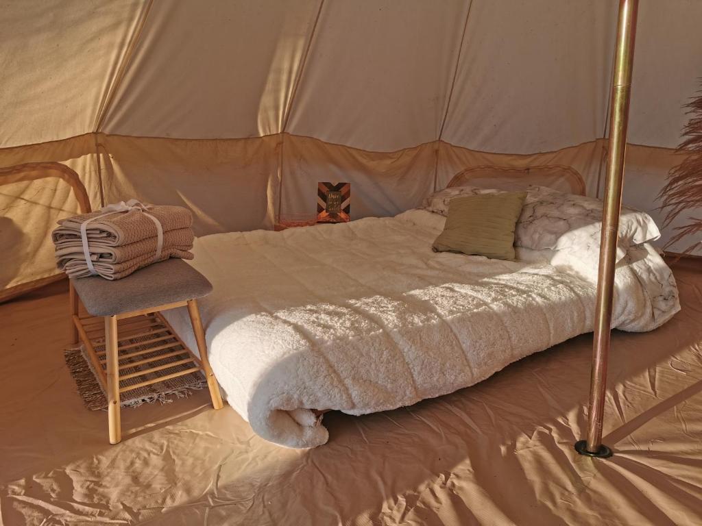 - un lit dans une tente avec une chaise à côté dans l'établissement #2 Sage & Wildflower, à Drumheller