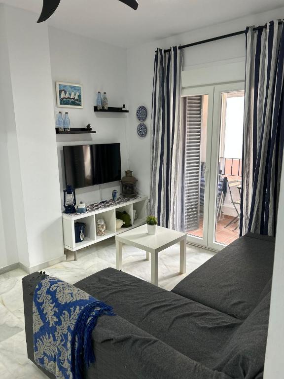sypialnia z łóżkiem, telewizorem i stołem w obiekcie APARTAMENTO CASA AZUL w mieście Zahara de los Atunes