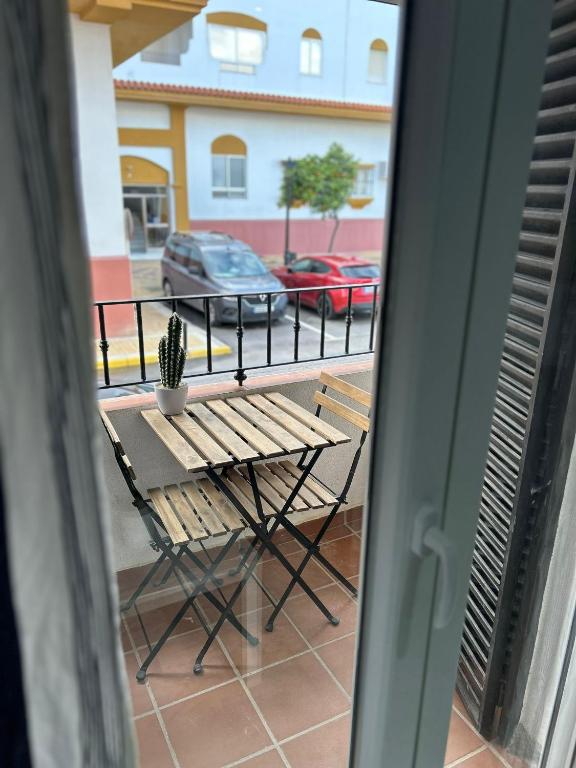 stół i krzesło na balkonie z widokiem na parking w obiekcie APARTAMENTO CASA AZUL w mieście Zahara de los Atunes