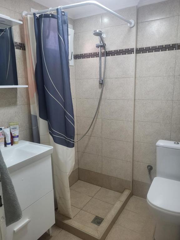 łazienka z prysznicem z niebieską zasłoną prysznicową w obiekcie Квартира Халкидики Флогита / Ferienwohnung Chalkidiki Griechenland w mieście Flogita