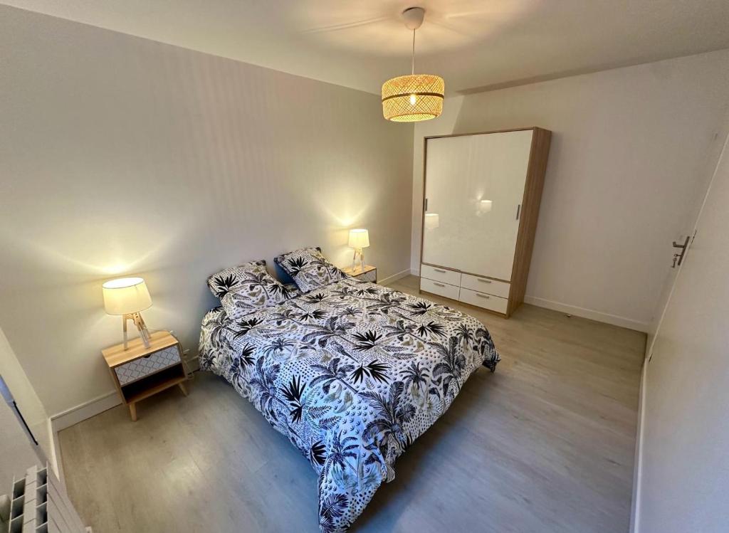 a bedroom with a bed and two lamps and a mirror at Maison de ville in Concarneau