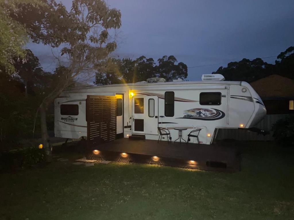 a white rv parked in a yard with a table at Well Appointed American Style Park Home in Kempsey