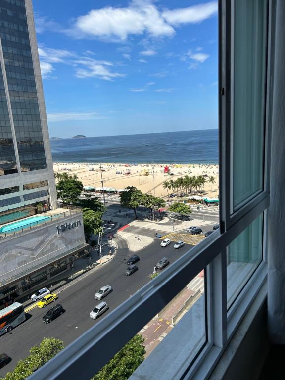 a view from a window of a street and the ocean at COPACABANA RIO PRAIA 18 in Rio de Janeiro