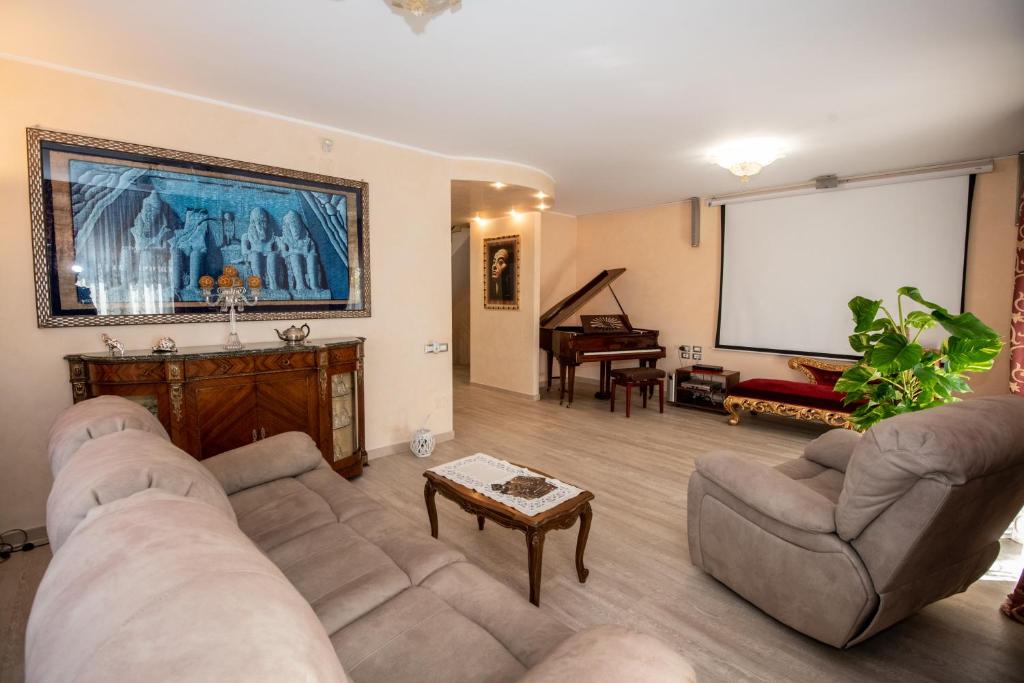 una sala de estar con 2 sofás y una pantalla de proyección en B&B CHIETI " Il SOGNO DI ARIS", en Chieti