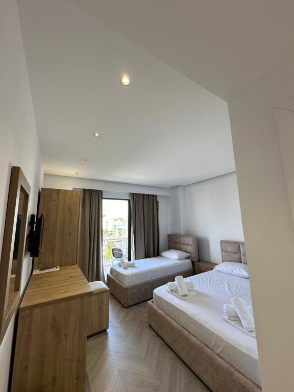 a hotel room with two beds and a couch at Noa Boutique Hotel in Ksamil