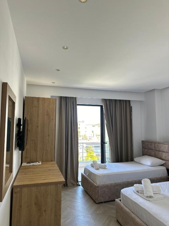 a hotel room with two beds and a balcony at Noa Boutique Hotel in Ksamil