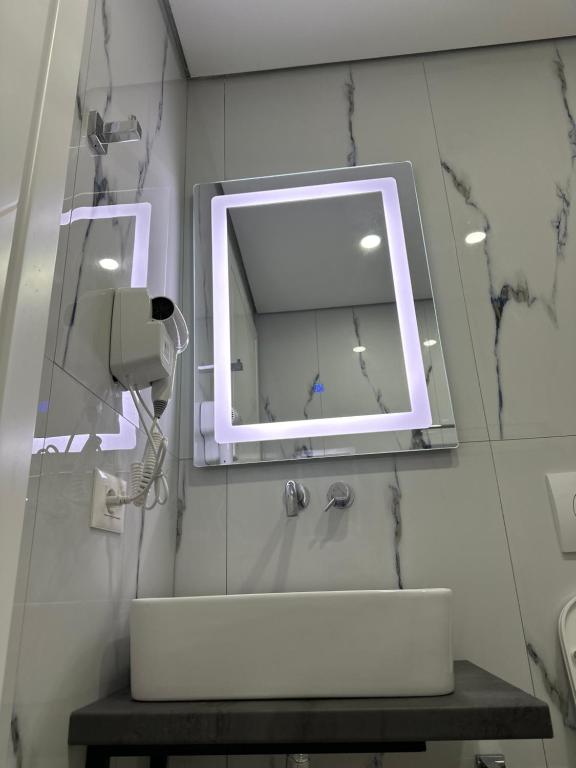 a bathroom with a white sink and a mirror at Noa Boutique Hotel in Ksamil