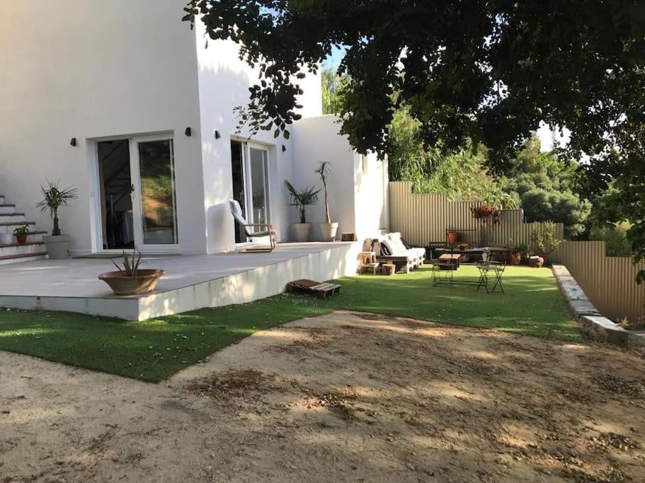 a white house with a yard with a patio at Villa Loba. Apartamento en casa rural. in Facinas