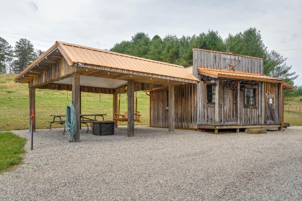 een houten gebouw met een picknicktafel ervoor bij Rustic Wellston Cabin with Fire Pits and ATV Trails! in Hamden