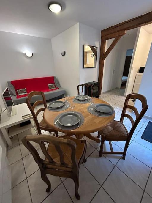 - une table et des chaises en bois dans l'établissement Le Montagnard, RDC 1 chambre, à Chartres