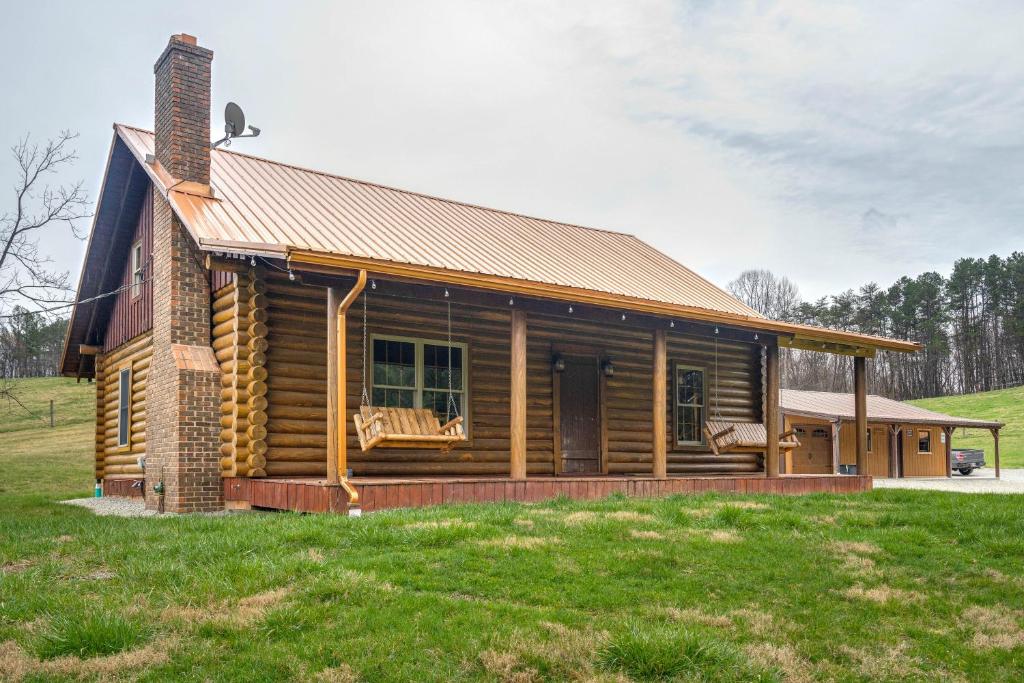 una cabaña de madera en un campo con césped en Rustic Wellston Cabin with Pond and ATV Trail Access! en Hamden