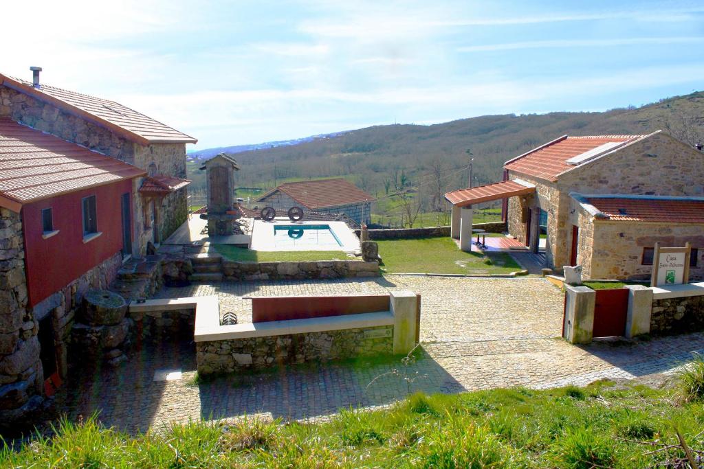 a group of buildings with a pool in a yard at Casa Entre-Palheiros e Casa do Canastro in Montalegre