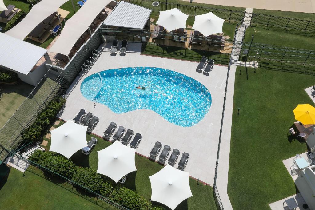 an overhead view of a pool with chairs and umbrellas at The Breakers in Gold Coast