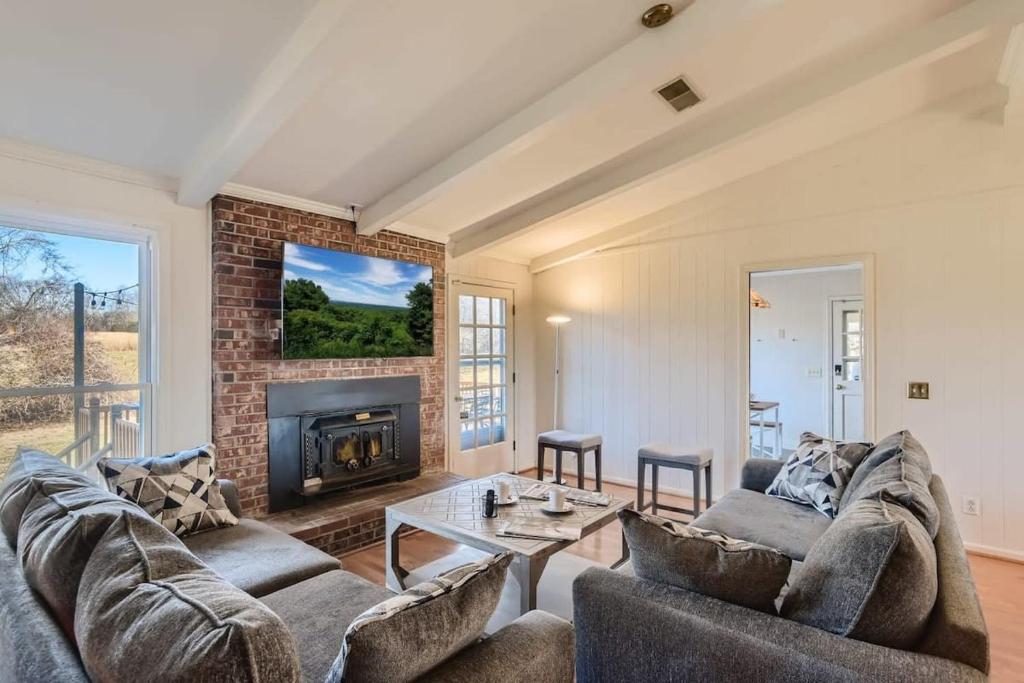 ein Wohnzimmer mit zwei Sofas und einem Kamin in der Unterkunft 5 Acre Farmhouse Near Nashville! in Spring Hill