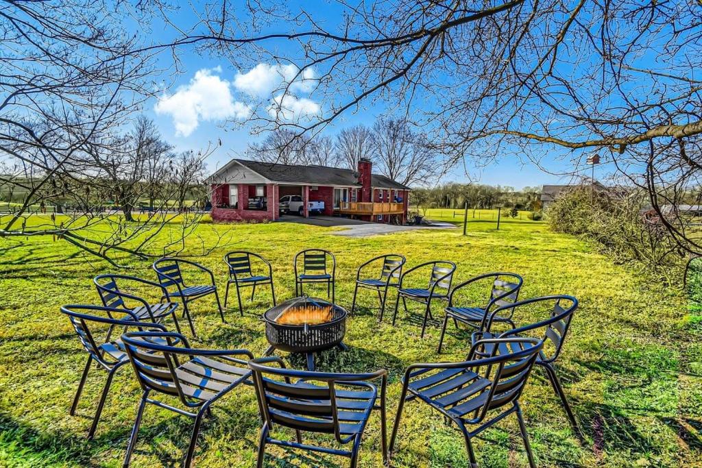 un gruppo di sedie e un tavolo con buca per il fuoco di NEW Amazing 5 Acre Ranch Home Near Nashville TA a Spring Hill