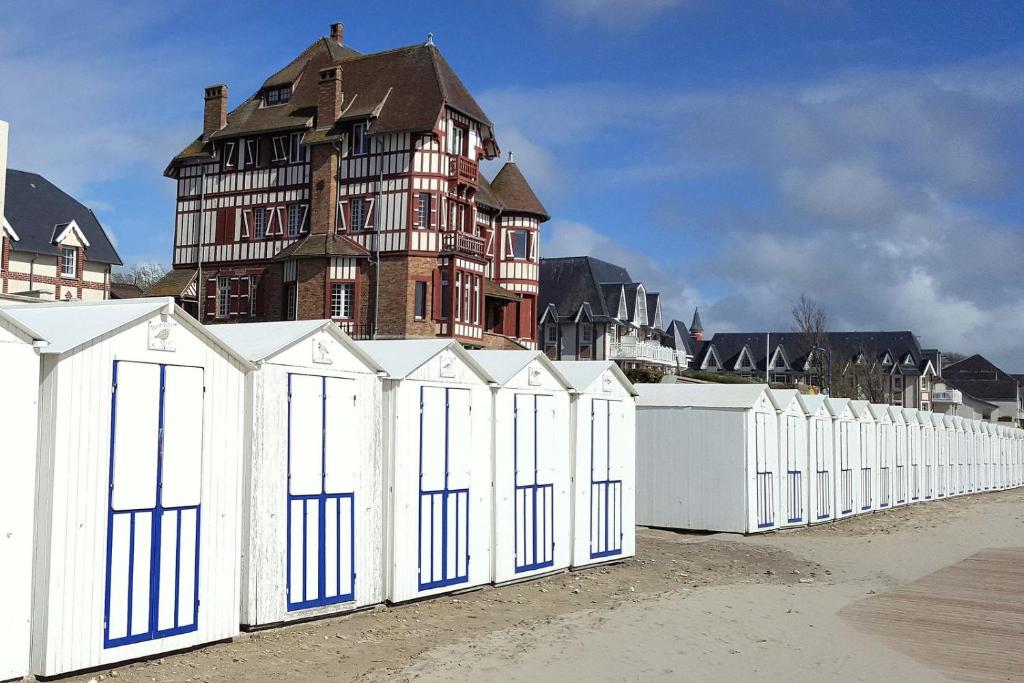 a white fence with a large house in the background at Maison Ariana 6 personnes à 5 min de la mer in Le Crotoy