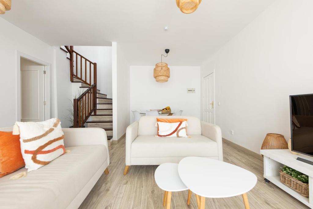 un soggiorno con divano bianco e tavolo di Casa Moure a Costa Teguise