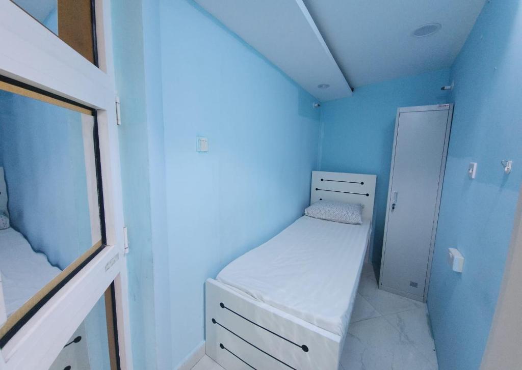 Habitación pequeña con cama y espejo. en Al Khaleez Accommodation, en Dubái