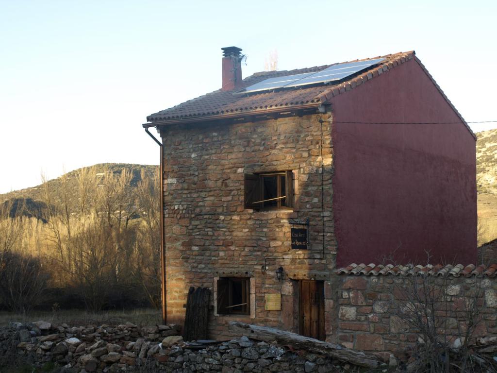 an old brick building with a red barn at Casa Rural La Tormenta in Albendiego
