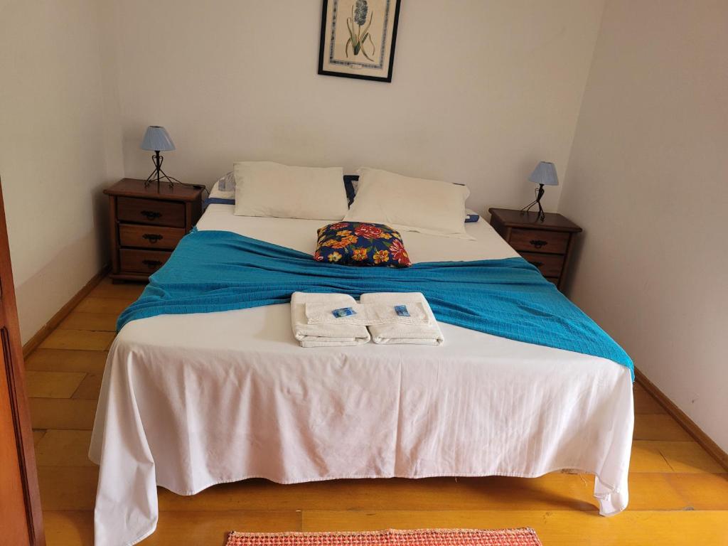 a bedroom with a bed with two towels on it at Ninho dos Passaros Penedo RJ in Penedo