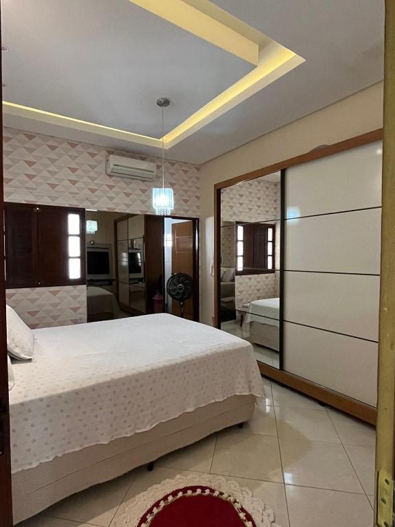 - une chambre avec un lit et un grand miroir dans l'établissement Casa Confort, à Juazeiro do Norte