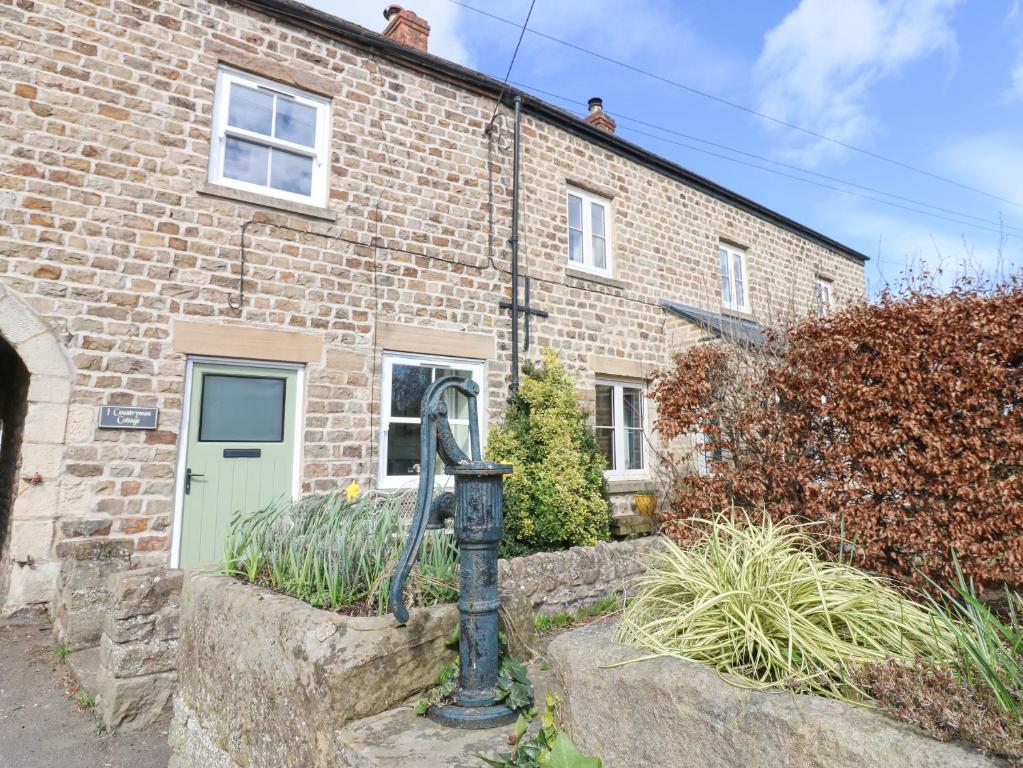 a statue in front of a brick house at 1 Countryman Inn Cottages in Hunton