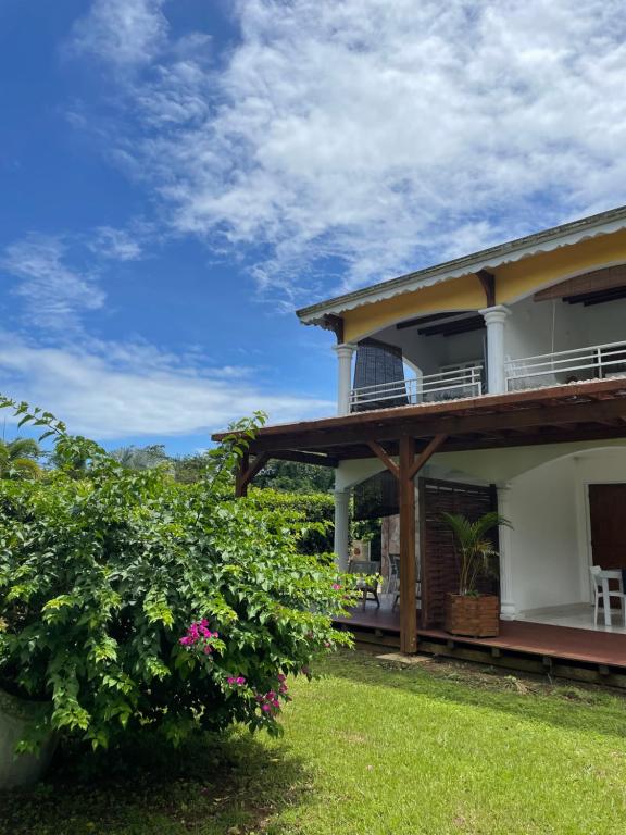 a house with a bush in front of it at Appartement Coeur de Papillon in Baie-Mahault