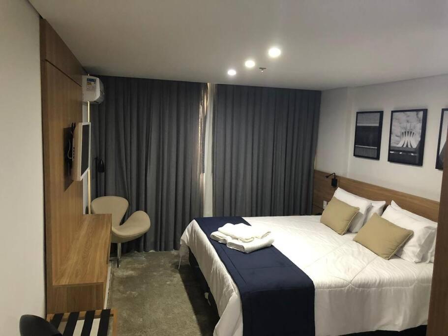 een hotelkamer met een groot bed en een stoel bij Flat Granja Brasil Resort in Petrópolis