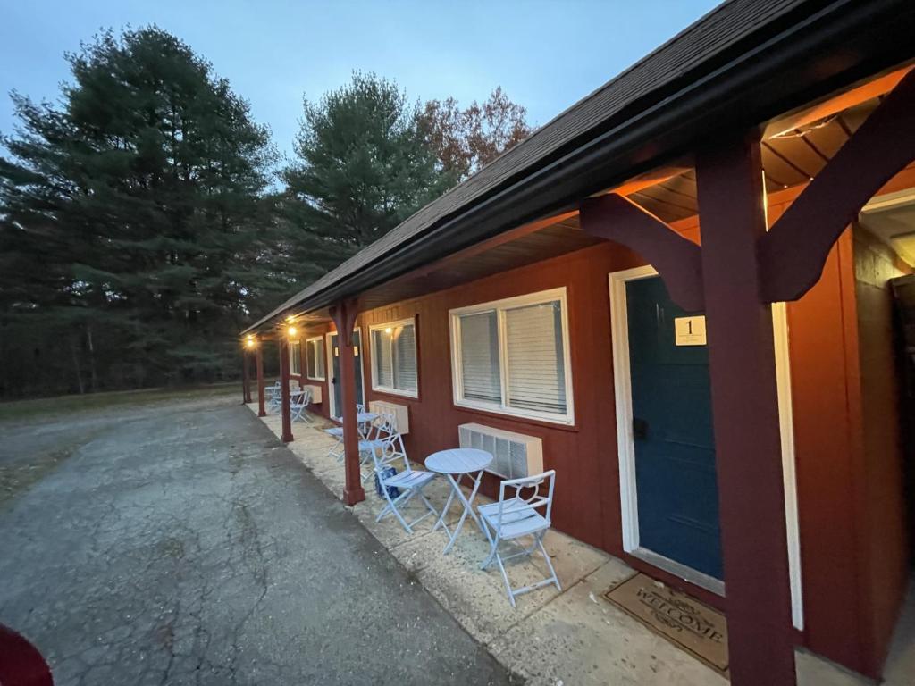 a house with two chairs and a table in front of it at Sweet Forest Breeze, A Cook Forest Inn in Marienville