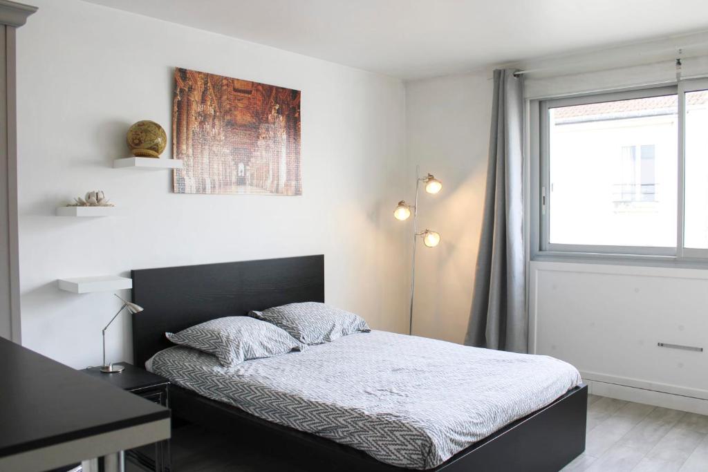 een slaapkamer met een bed, een bureau en een raam bij Nice studio close to Paris in Montrouge