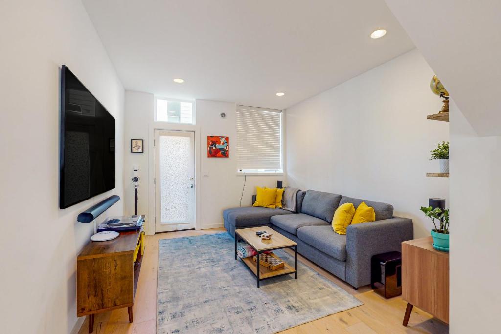 Urban Oasis في سياتل: غرفة معيشة مع أريكة زرقاء ووسائد صفراء