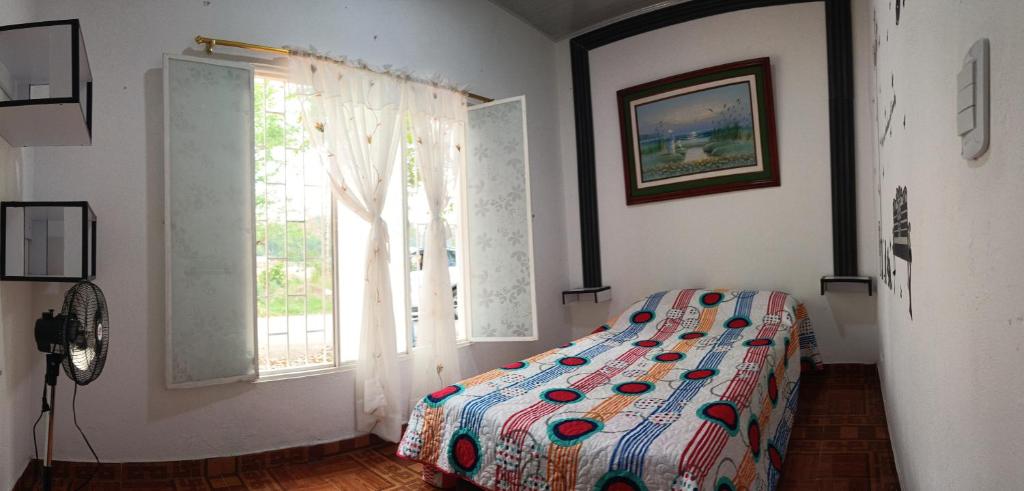 a bedroom with a bed and a window at CASA DANY in Guaduas
