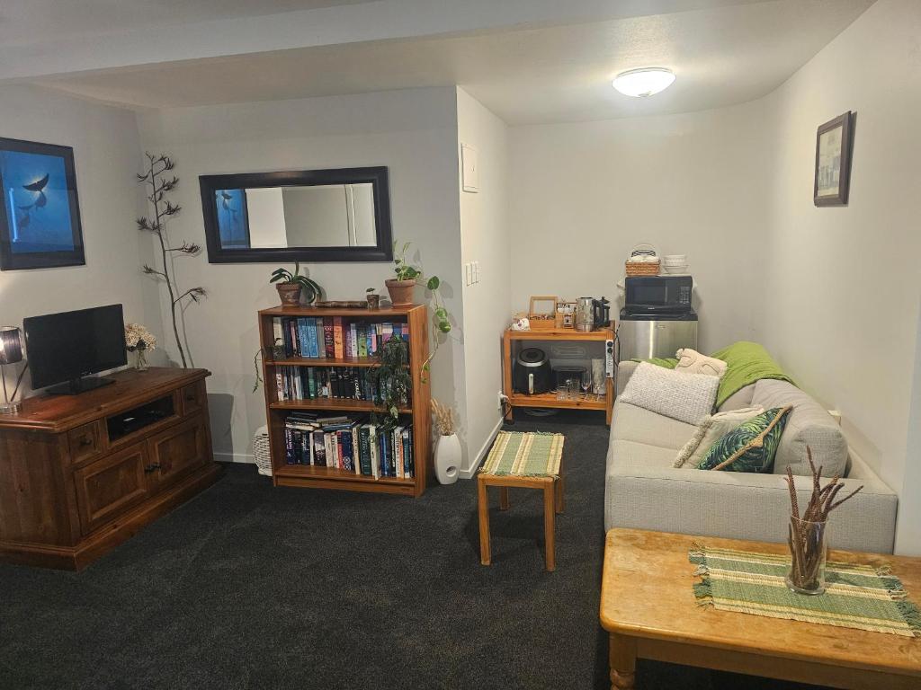- un salon avec un canapé et une télévision dans l'établissement The Bunker Torbay, à Auckland