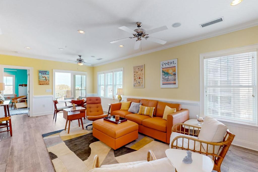 a living room with an orange couch and chairs at Lucky Break in Hatteras