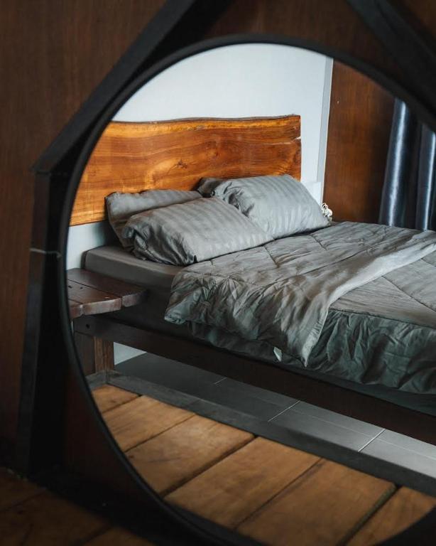 a mirror reflecting a bed in a bedroom at Pondok Beach Shack in Tioman Island