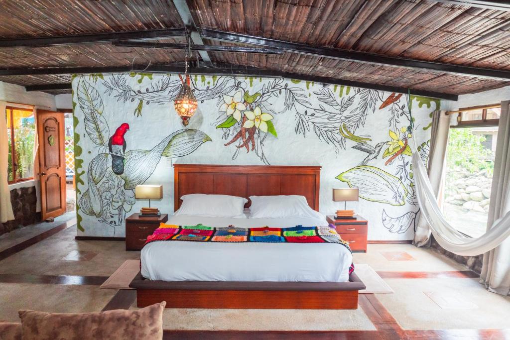 - une chambre avec un lit orné d'une peinture murale dans l'établissement Spa Hosteria Miramelindo, à Baños