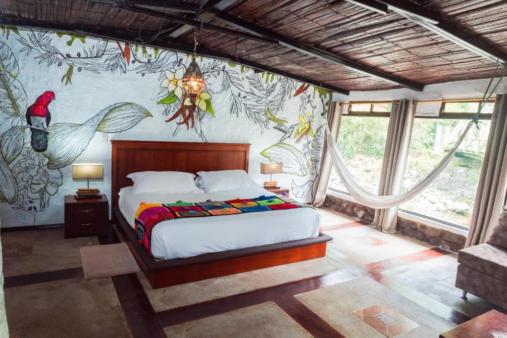 Un dormitorio con una cama con un cuadro en la pared. en Spa Hosteria Miramelindo, en Baños