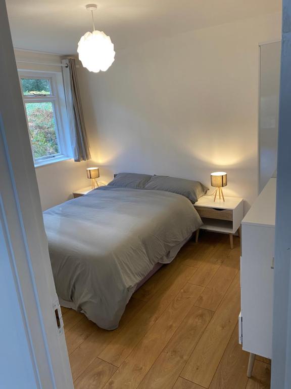 a bedroom with a bed and two lamps on two tables at Rose lodge in Dublin