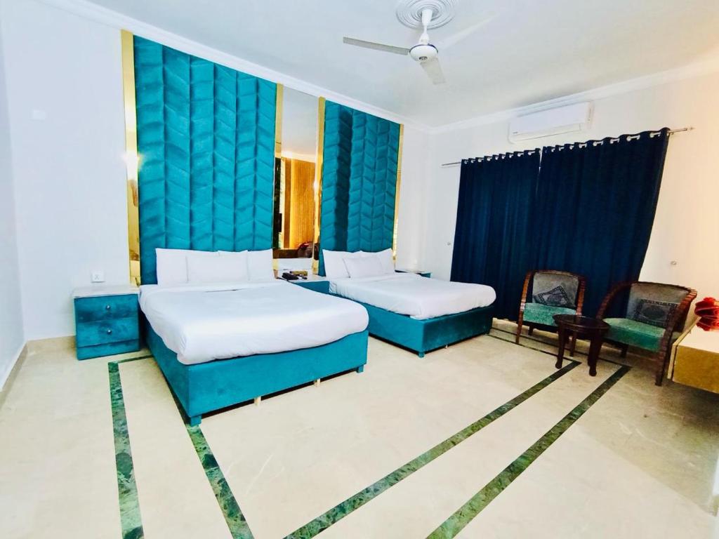 a hotel room with two beds and a blue curtain at Hayat Grand in Islamabad