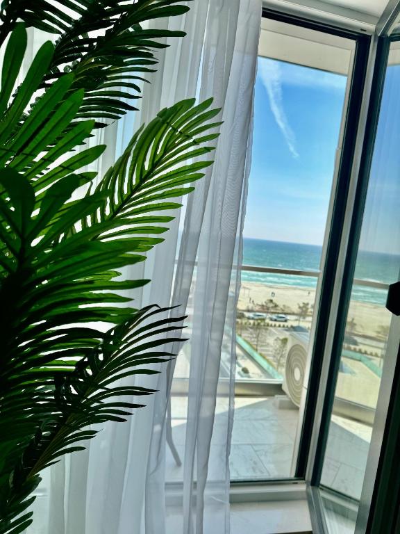 a window with a view of the beach and the ocean at Heaven Infinity Sunrise Pool & SPA in Mamaia Sat/Năvodari